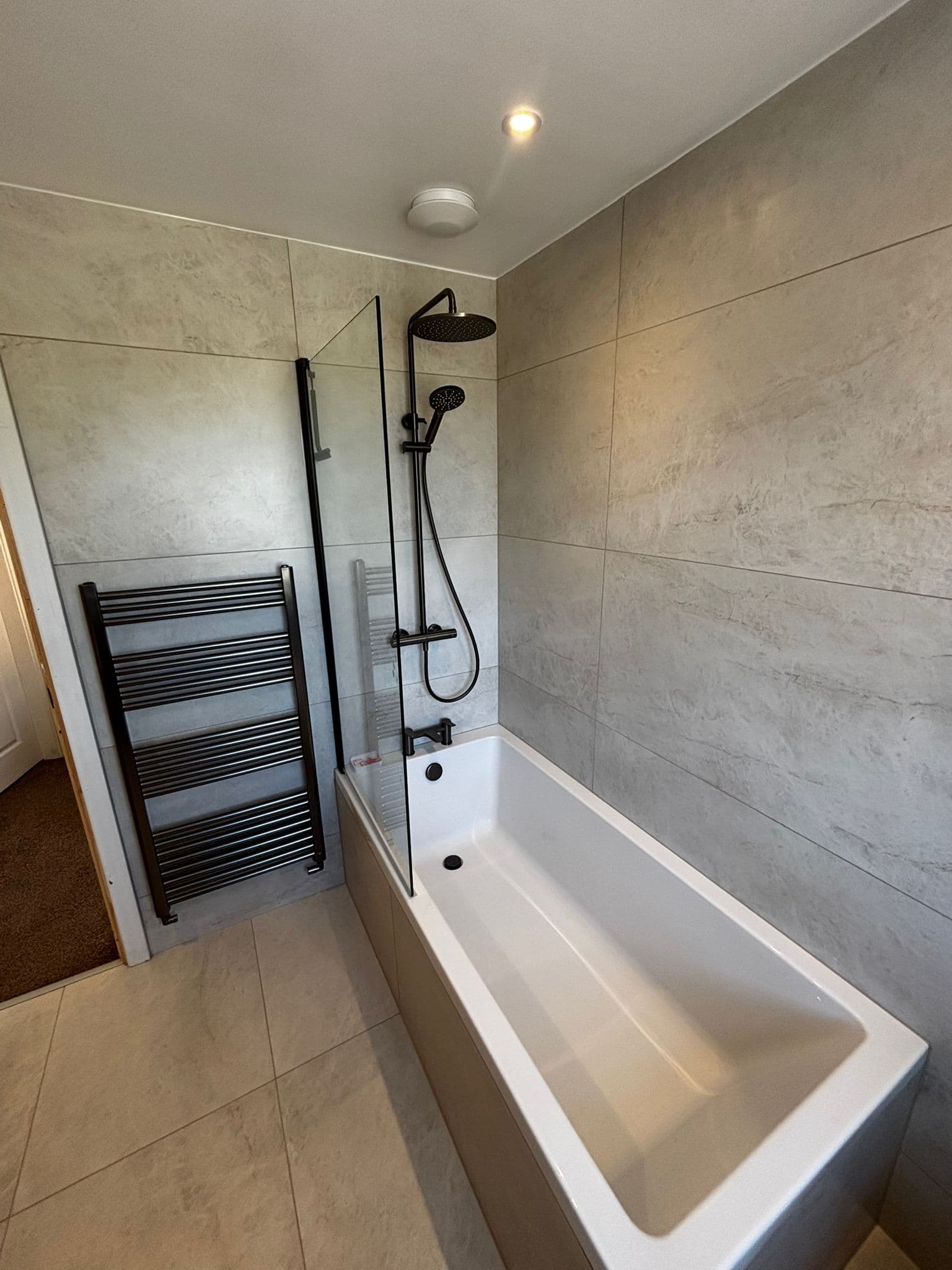 Second bathroom in matching finish with black shower, mirror cabinet and walnut vanity