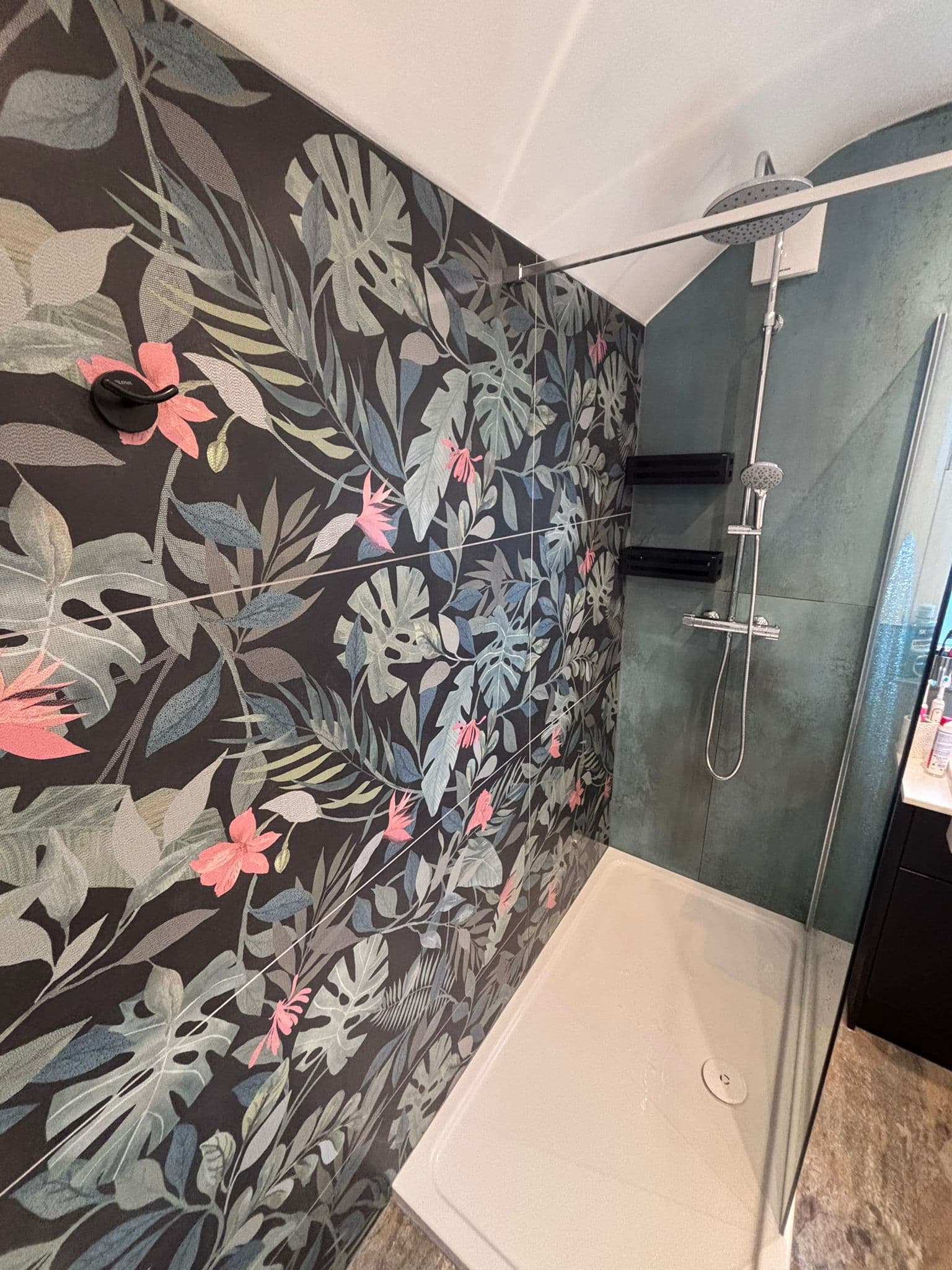 Chrome bar shower with rainfall head and handset against tropical feature tiles