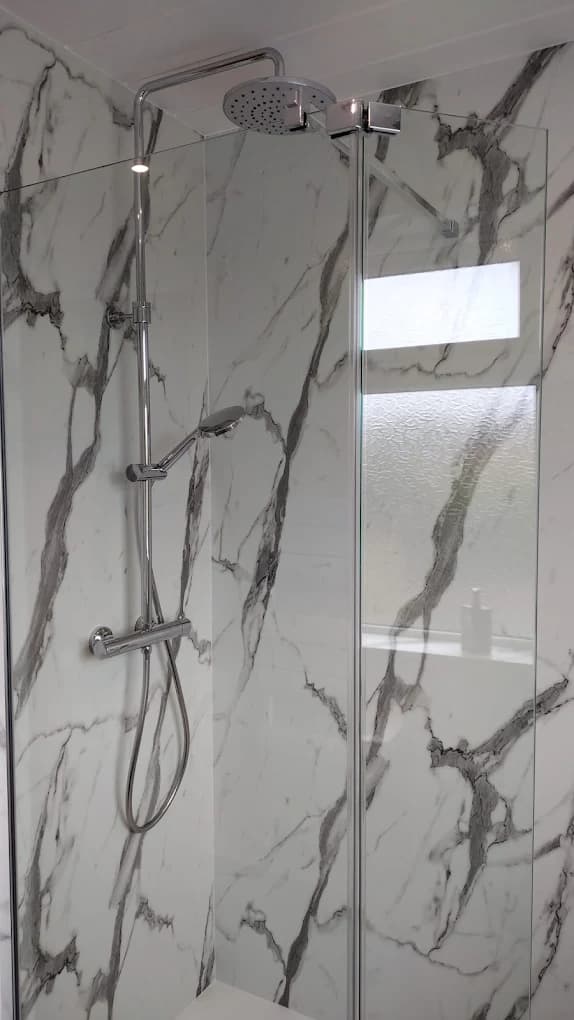 Marble-effect shower panel with a chrome rainfall shower