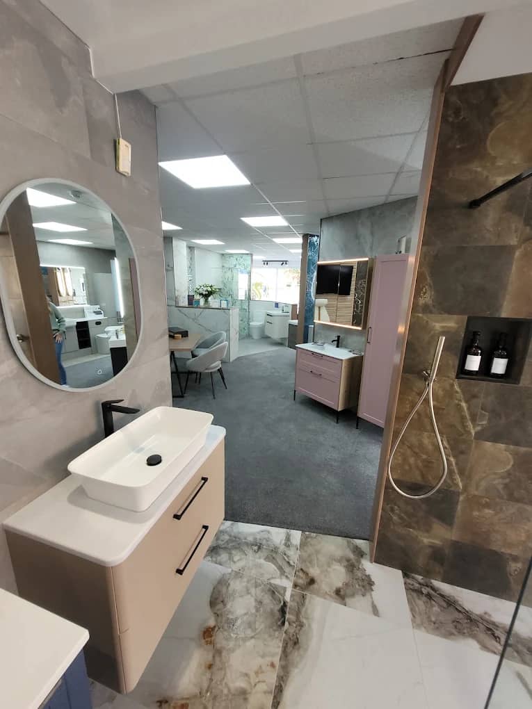 Showroom display with a basin, round mirror and stone-effect feature tiles